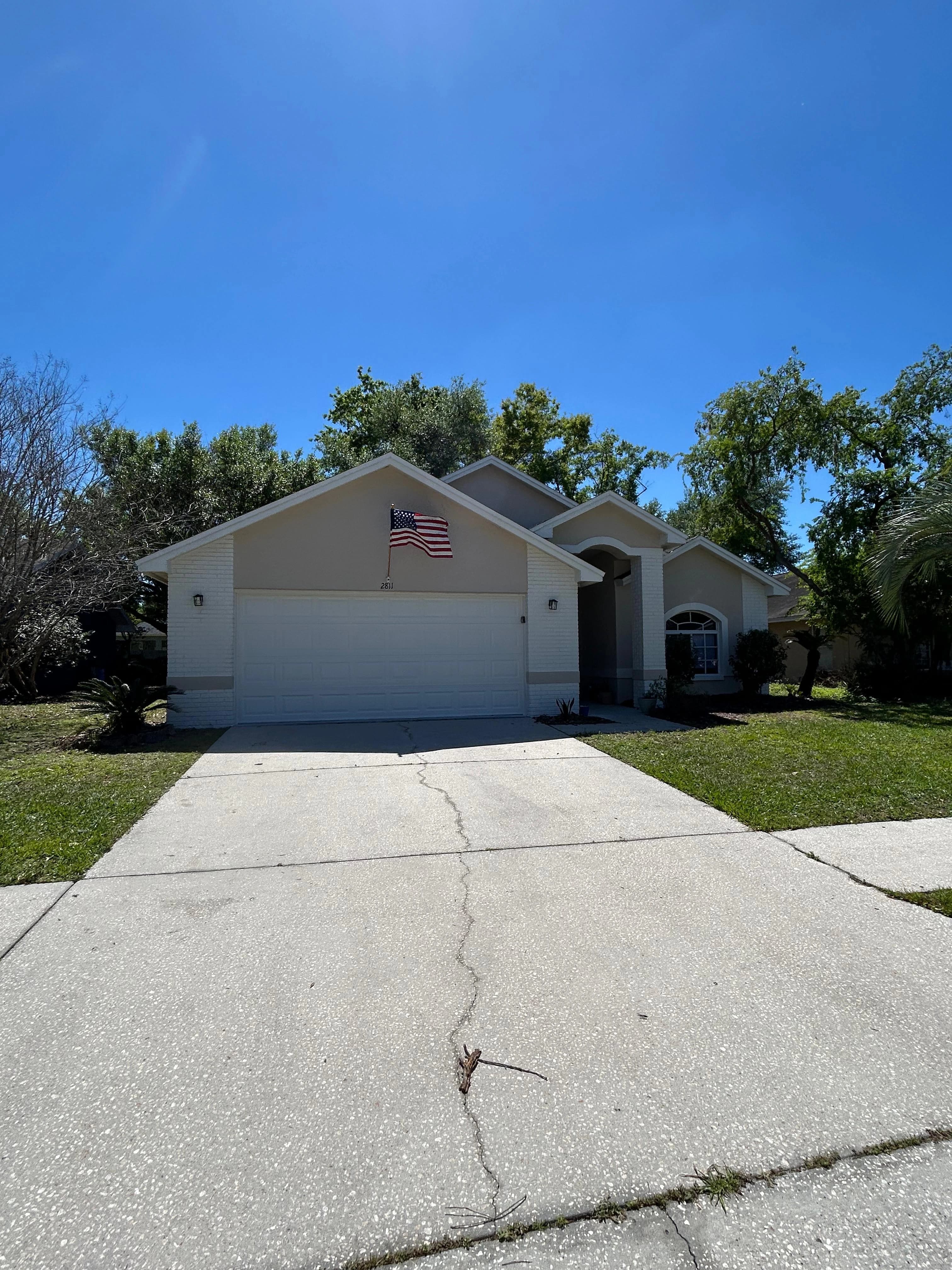 Florida home exterior renovation with painted brick and two-car garage — Central Florida Renovations